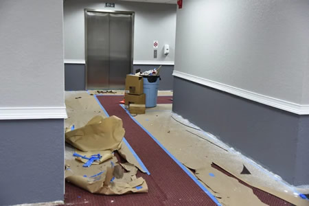 Crew applying high build interior coating on a hercules ca office